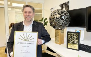 Magnus Lindgren visar upp diplom, vandringspokel och utmärkelse för Årets Företagare.